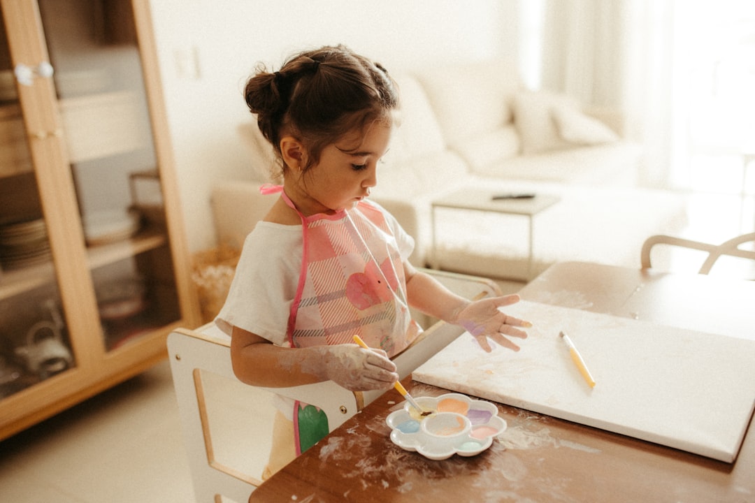 Young girl painting at a table with watercolors