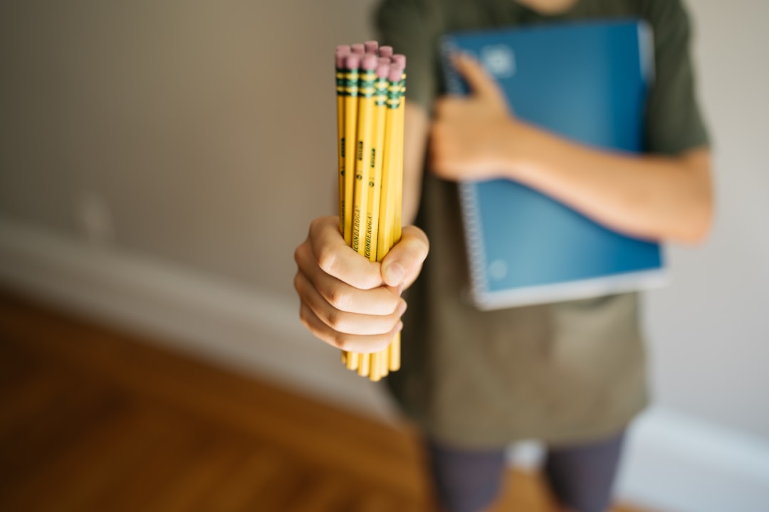 Student holding pencils and a notebook, illustrating a quick decision moment to help, step back, or worry.