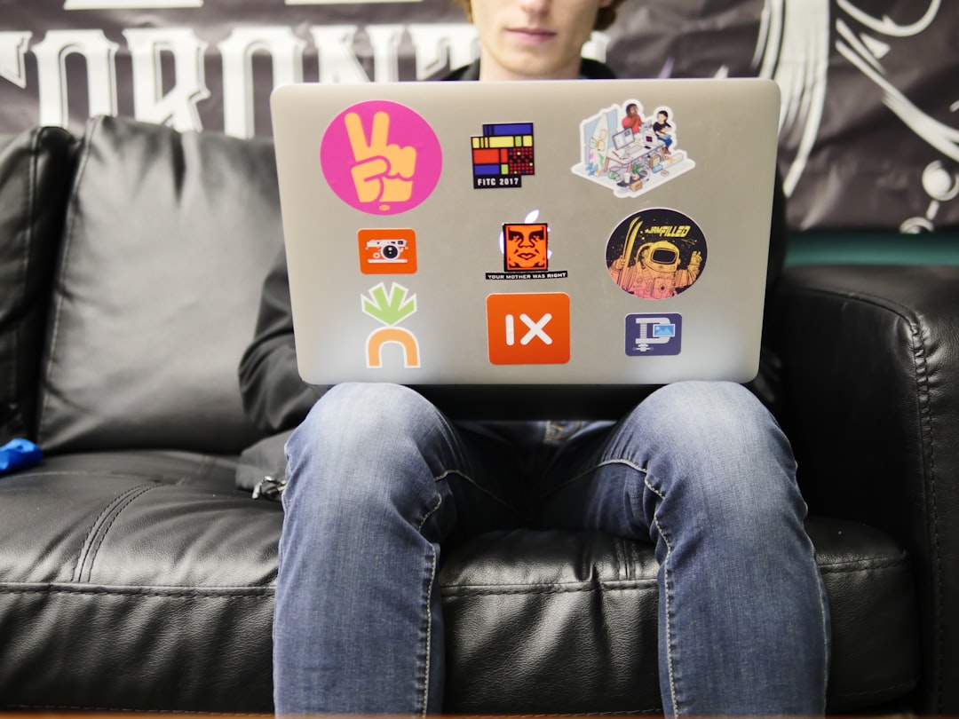 Student using a sticker-covered laptop, symbolizing how school success must translate into real AI-era job skills.
