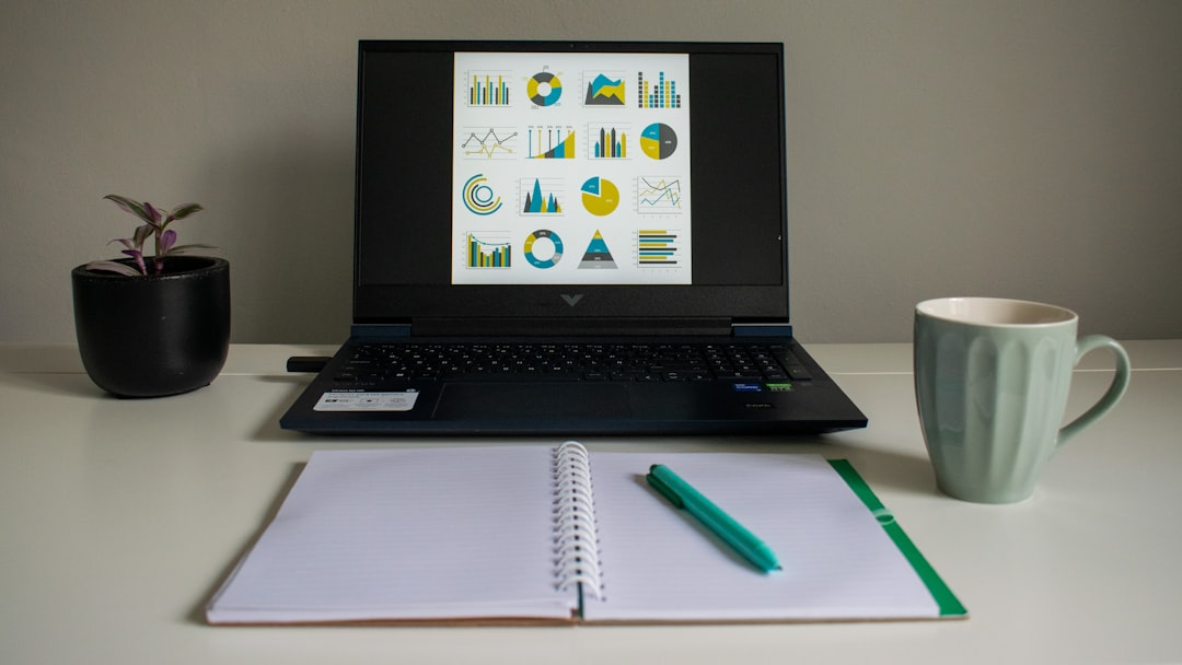 Laptop displaying charts and data visualizations beside a notebook, illustrating how gaming leads to statistics and data analysis skills.