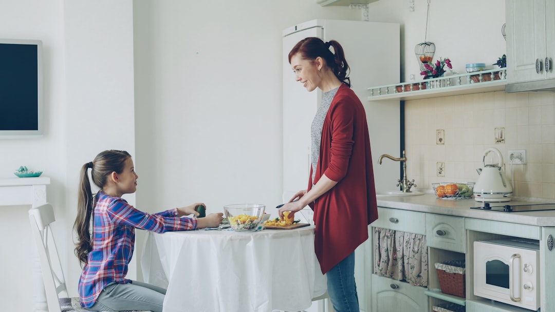 Mother and daughter talking in kitchen, illustrating how parents and teens often have different perceptions of school engagement