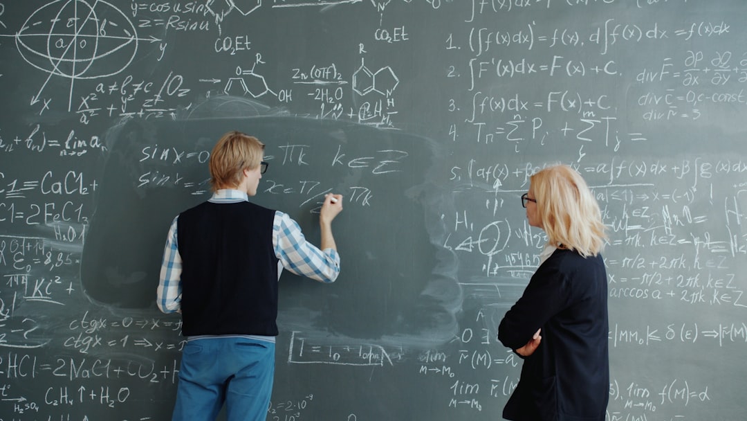 Teacher explains chemistry ideas at a chalkboard with formulas, emphasizing understanding over memorizing equations in AP Chemistry.