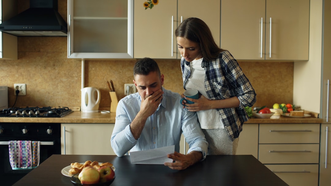A distressed young man supported by his wife, showing emotional overwhelm that mirrors a teen's apathy as a stress response, not a character flaw