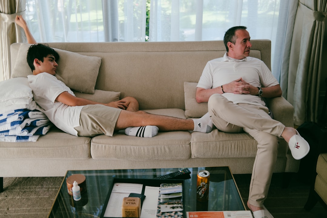 Two men relaxing and talking openly on a sofa, representing a low-pressure, open conversation approach between a parent and teen
