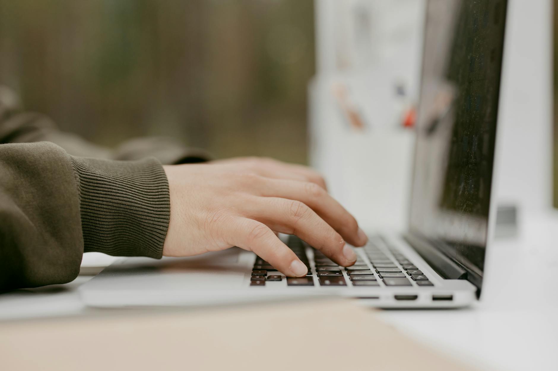 Close-up of hands typing on a laptop keyboard. Building code, building skills