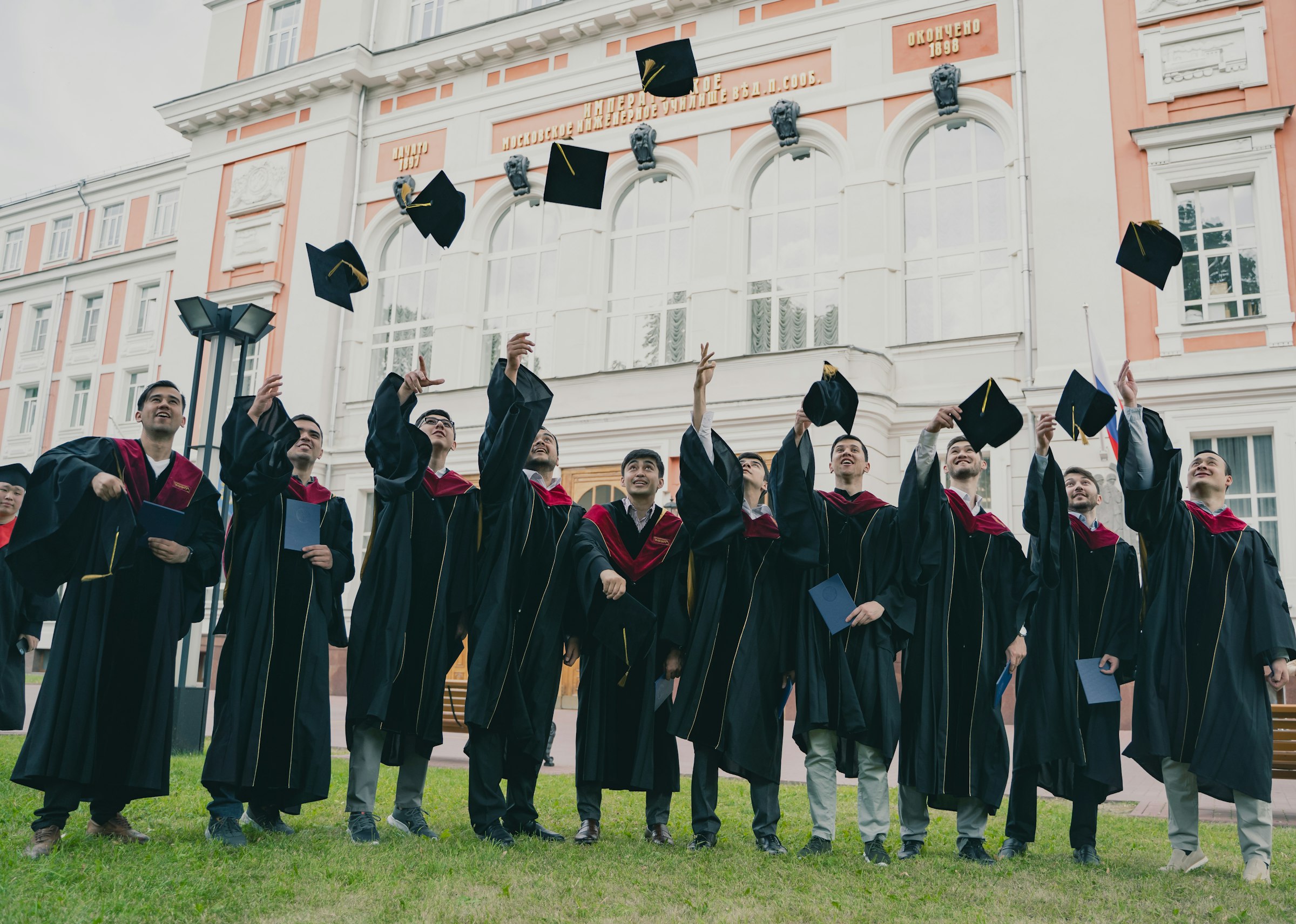 Graduates celebrating with caps raised, representing student achievement and success