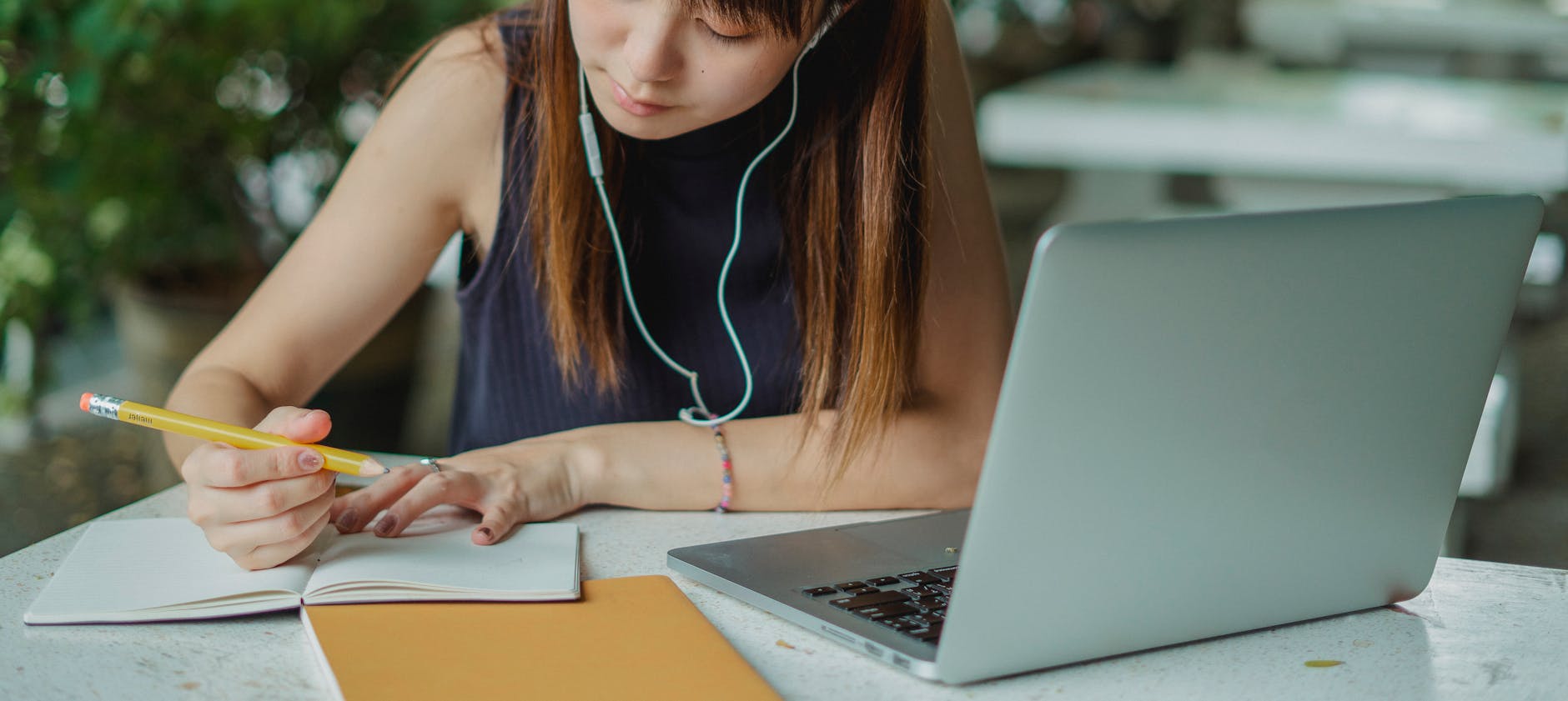Young woman taking notes while studying, focused literary analysis