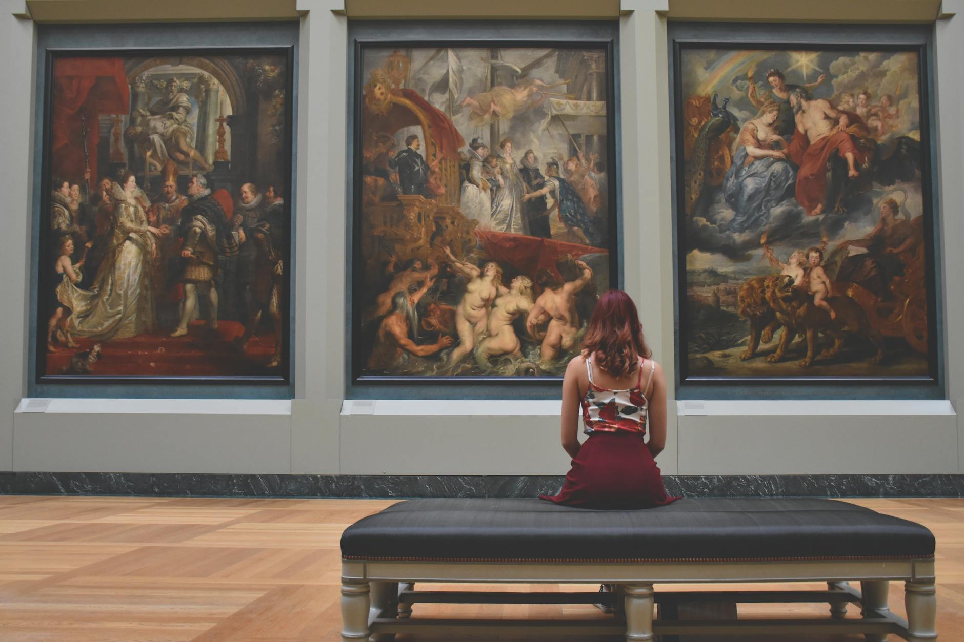 Woman observing classic paintings in museum gallery, the art of humanities education