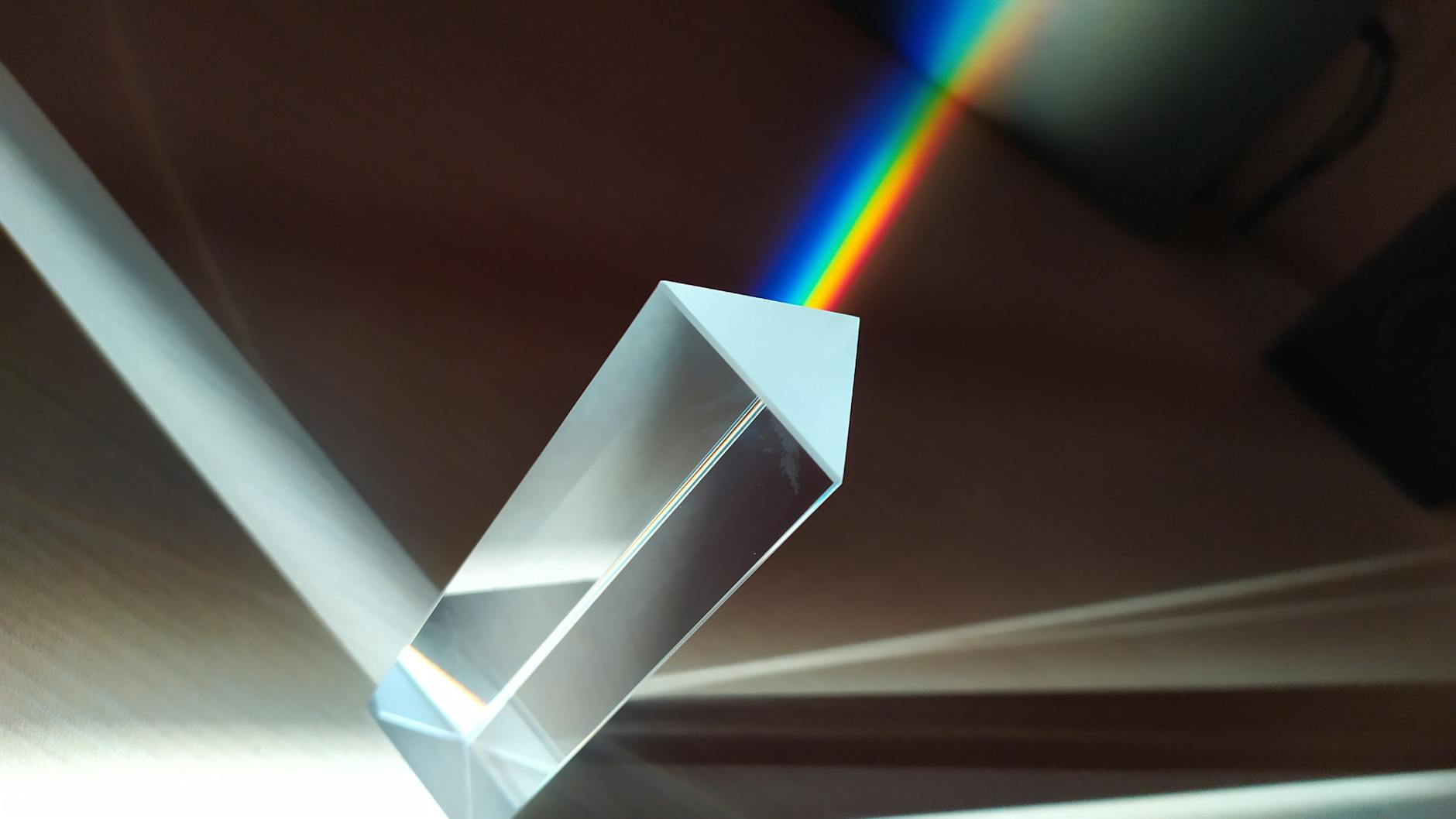 Glass prism creating vivid rainbow reflection, the beauty of scientific discovery