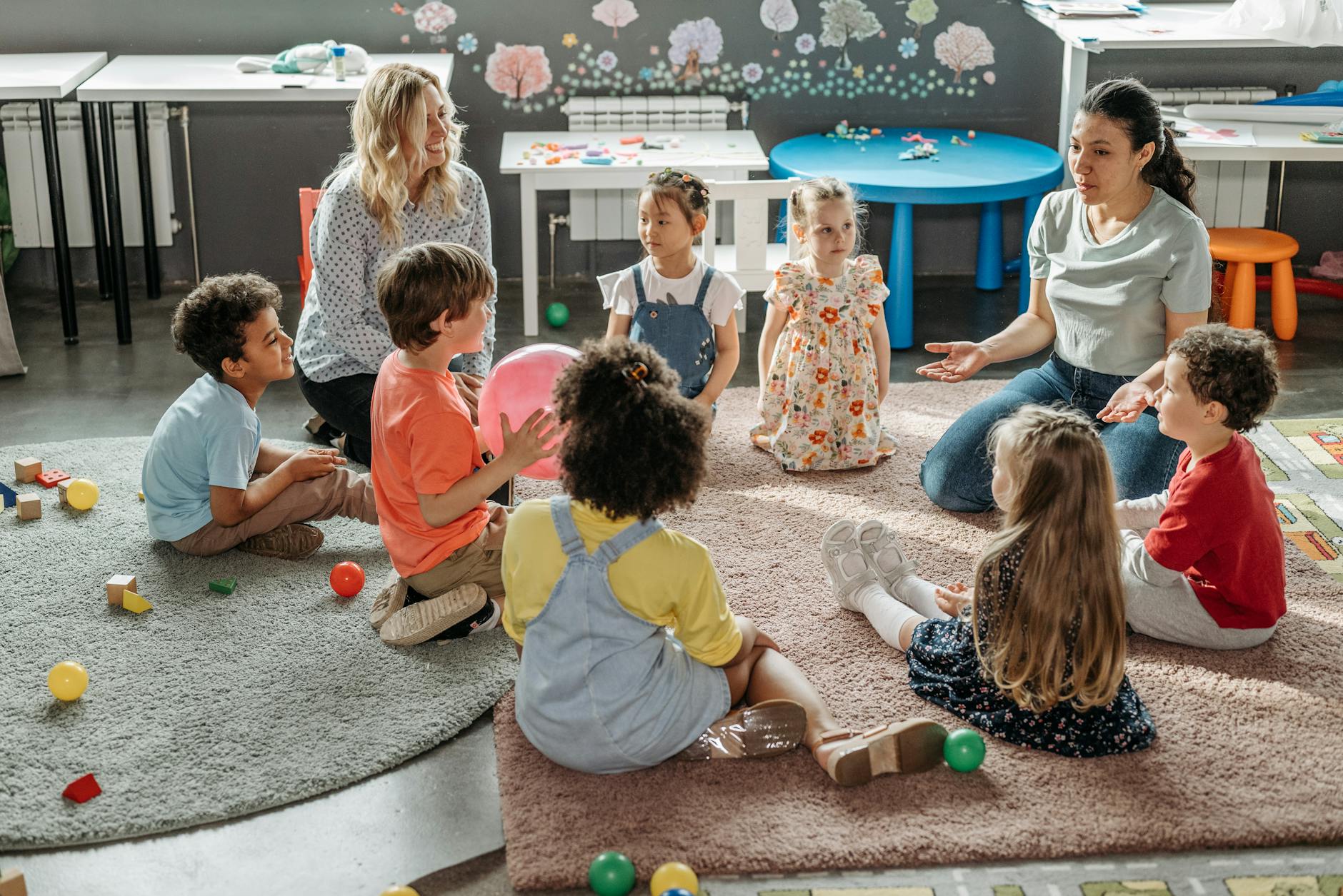 Children in circle time with teachers, engaging in a kindergarten classroom activity